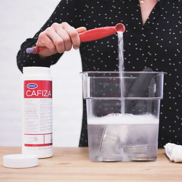 Cafiza powder soaking espresso machine parts during cleaning